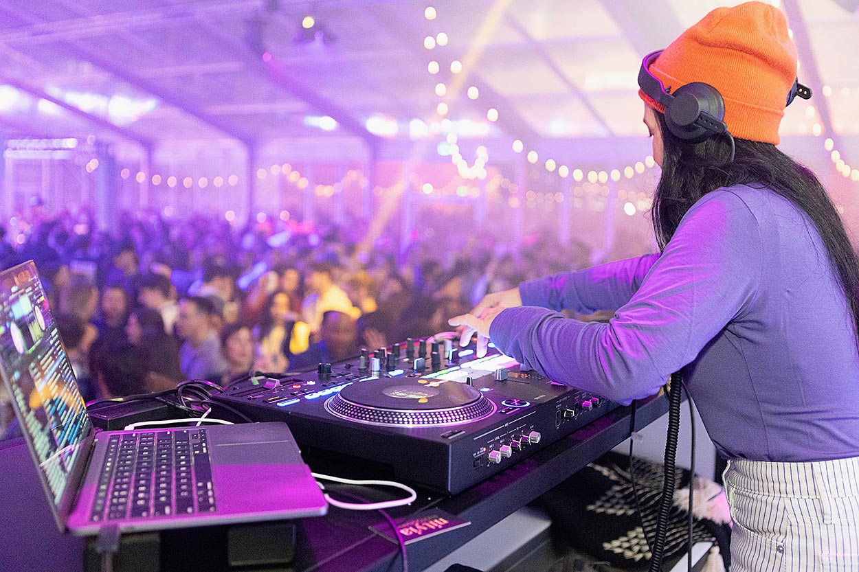 close up of DJ working the decks with crowd blurred in background