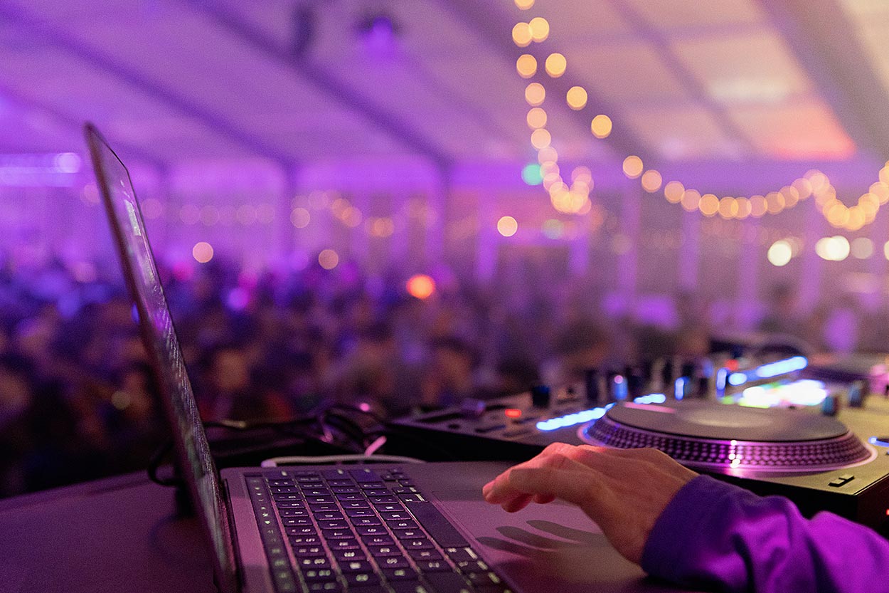 Dj hand with event crowd blurred in background