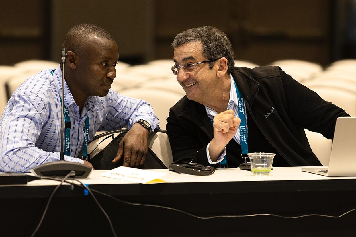 two conference attendees caught smiling and chatting