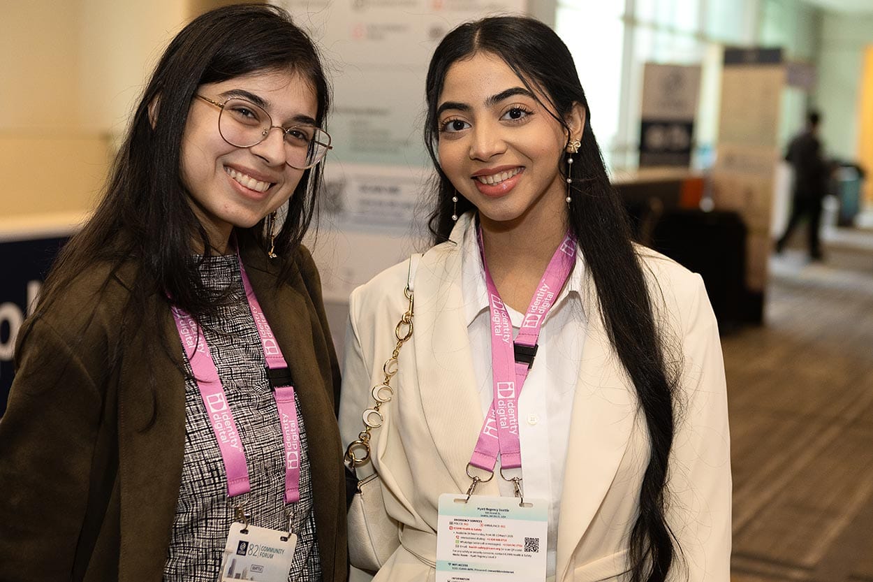 two young women smiling with event lanyards