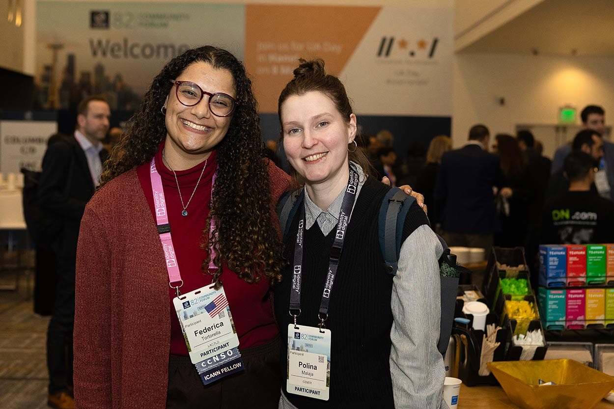 Conference attendees with event sign in background