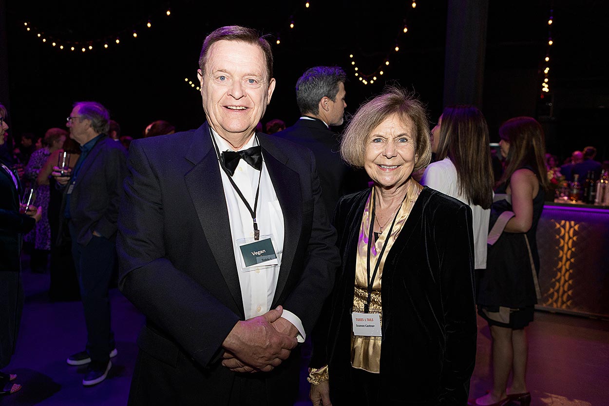 Two guest in tux and fancy attire at a fundraiser
