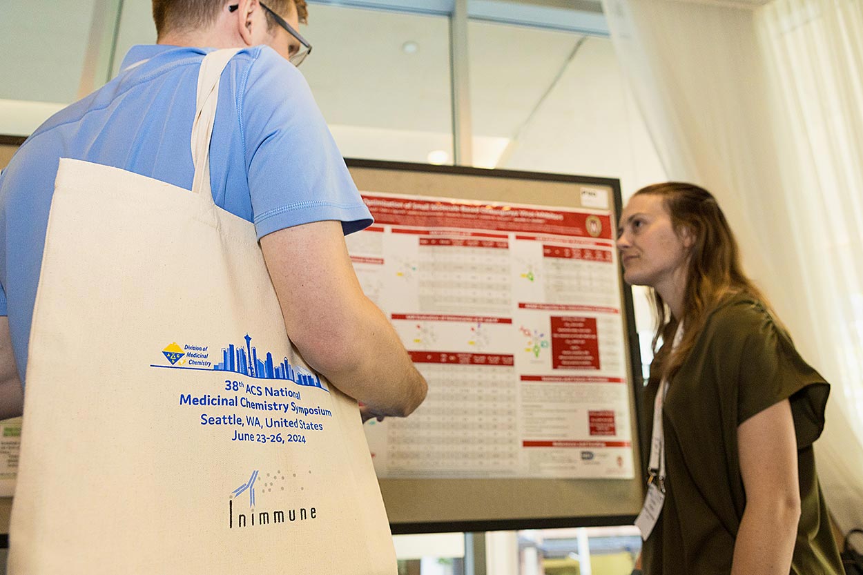 Low view of a branded conference bag and woman presenting a poster