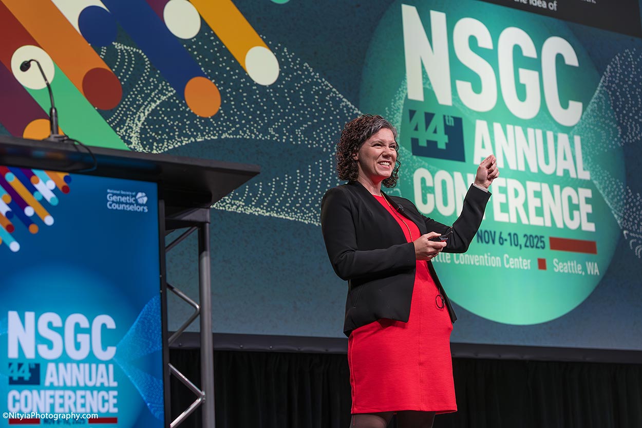 Keynote speaker in a red dress at National Society of Genetic Counselors annual conference