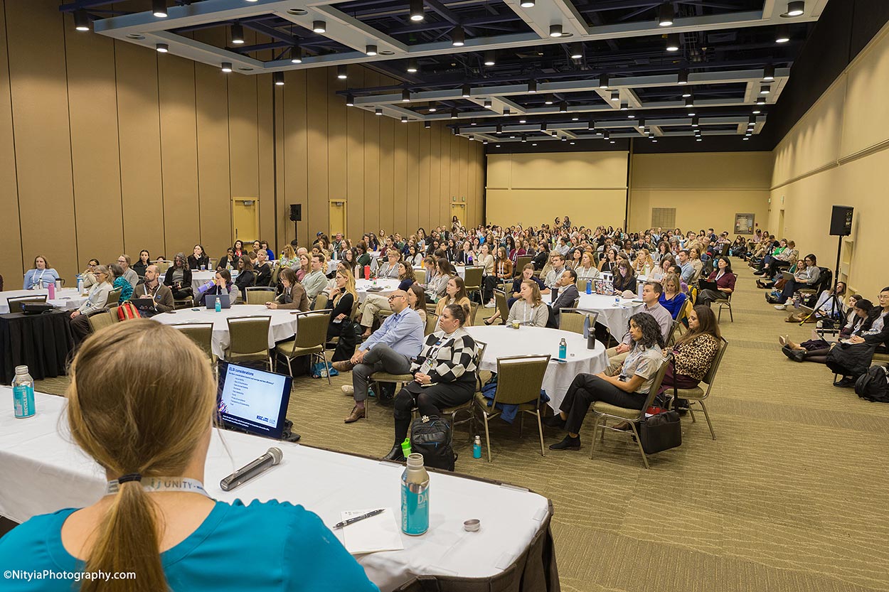 Creative view of a speaker with room full of conference attendees