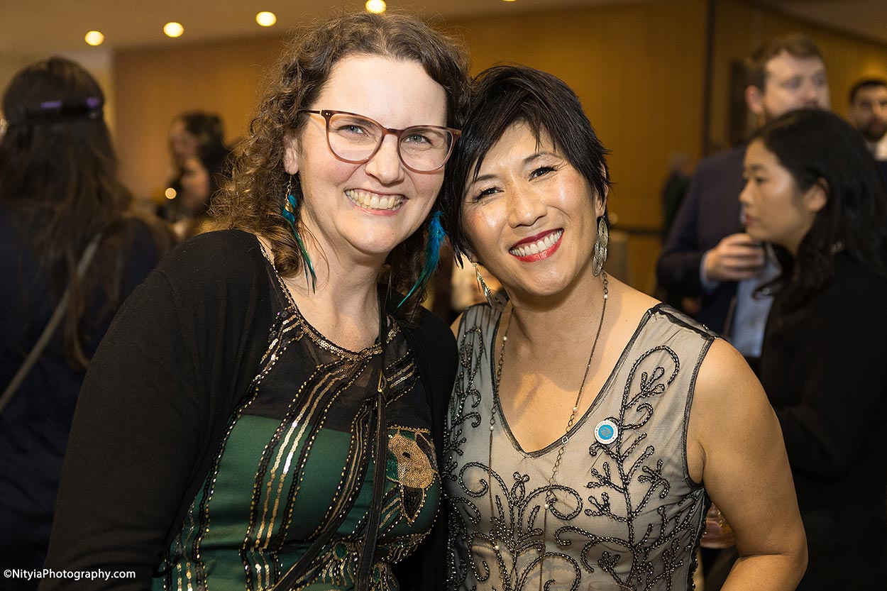 Two women with big smiles and sparkly dresses